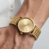 Gold minimalist old money watch dial close-up on wrist with white Henley t-shirt - AURA FASHION