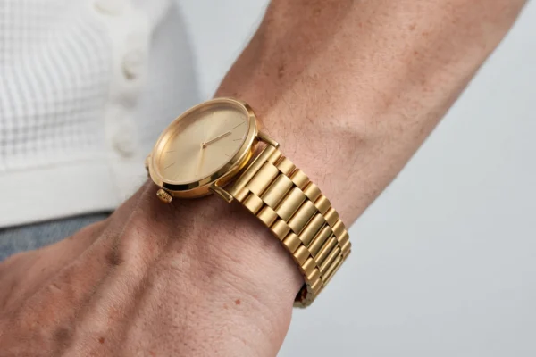 Gold minimalist watch side view showing bracelet links and case thickness - AURA FASHION